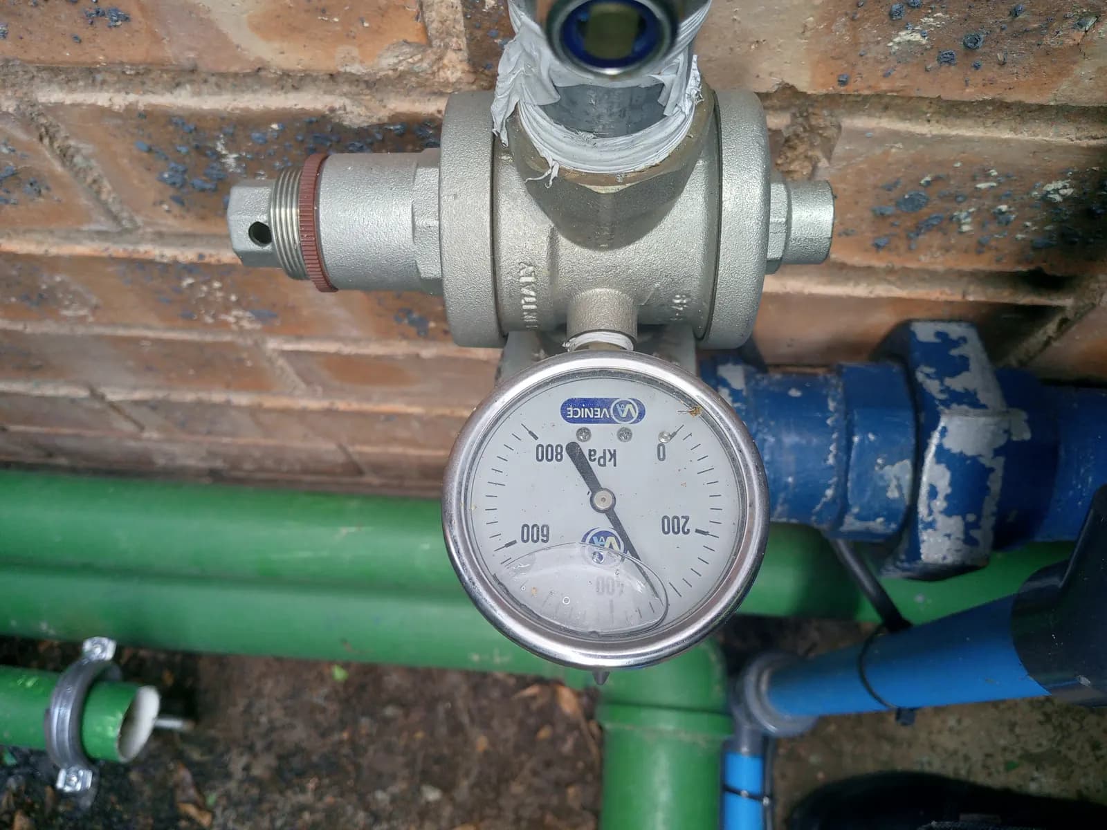 A pressure-reducing valve and gauge fitted into a reticulation line, with isolation valves on the pipework either side.