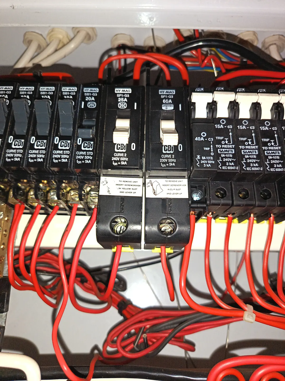 Control panel wiring: circuit breakers on a rail with the loop wiring dressed and terminated behind them.