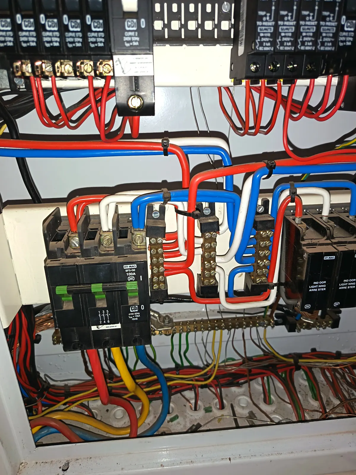 Contactors and terminal rails inside a control panel, with the loom dressed across the backplate to the terminals at the base.
